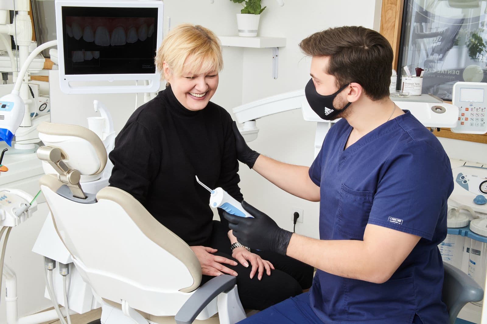 A dentist warmly sharing a patient's treatment results together