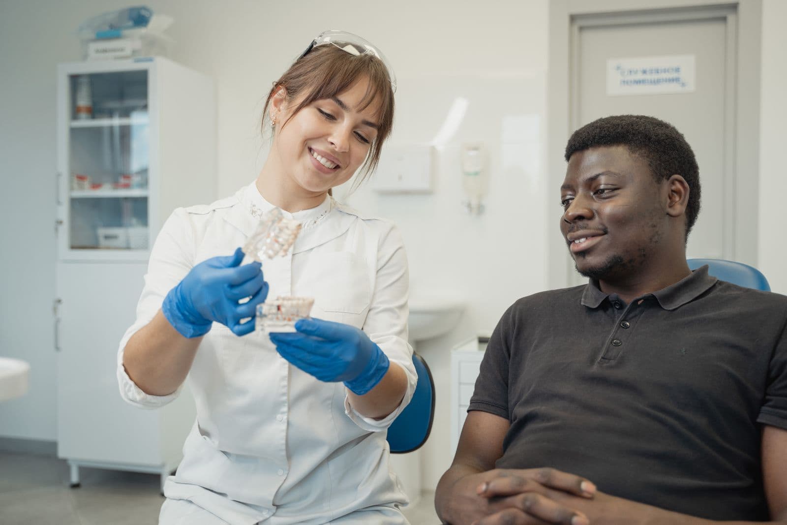 A dentist showing a patient a dental model during a warm consultation