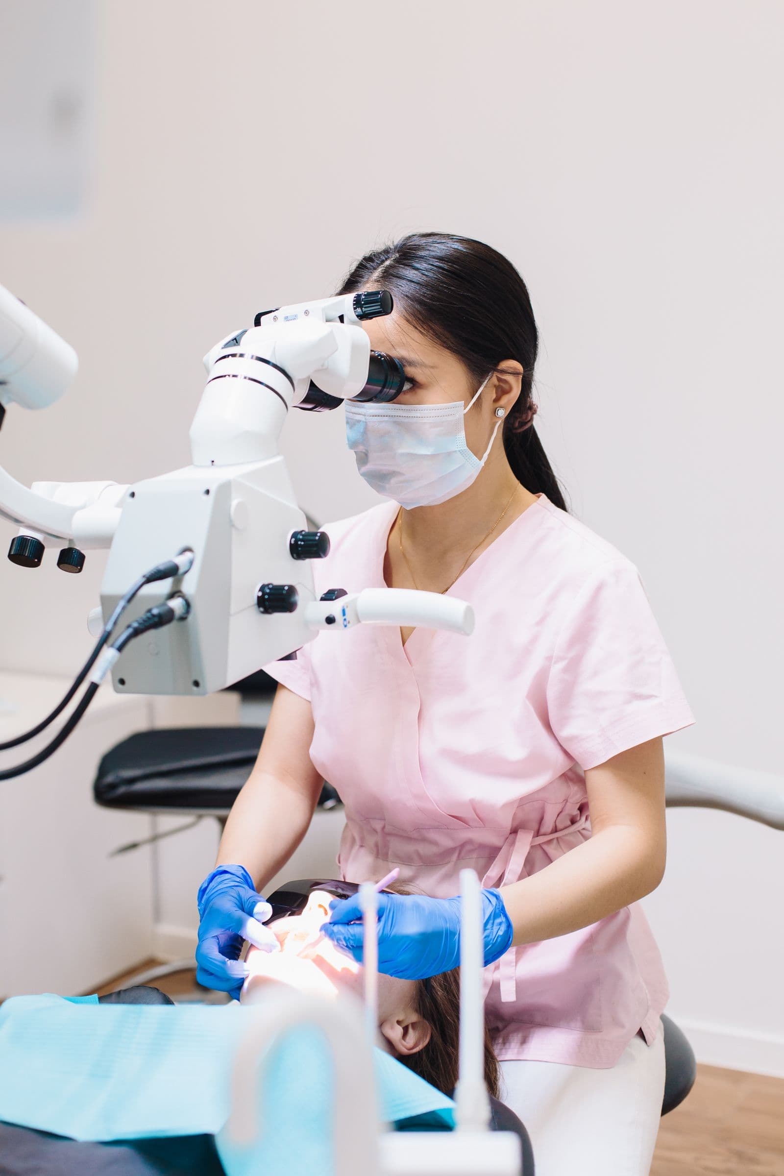 Dentist using a surgical microscope for precision treatment